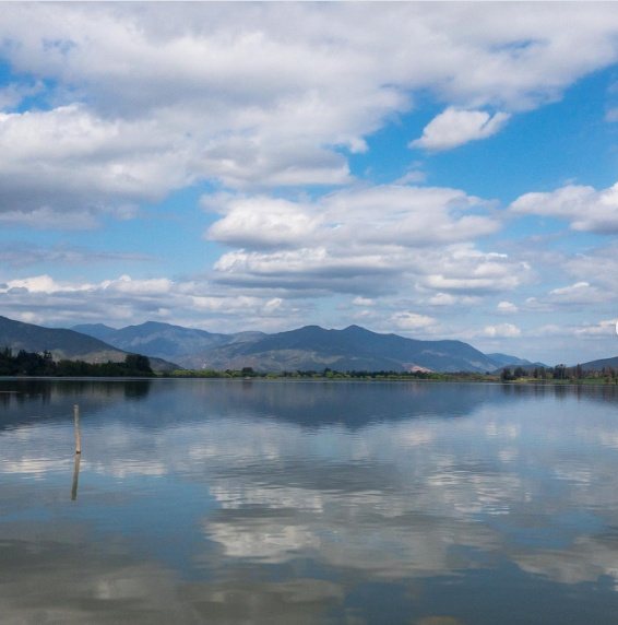 Nubes y cerros reflejados en el lago
